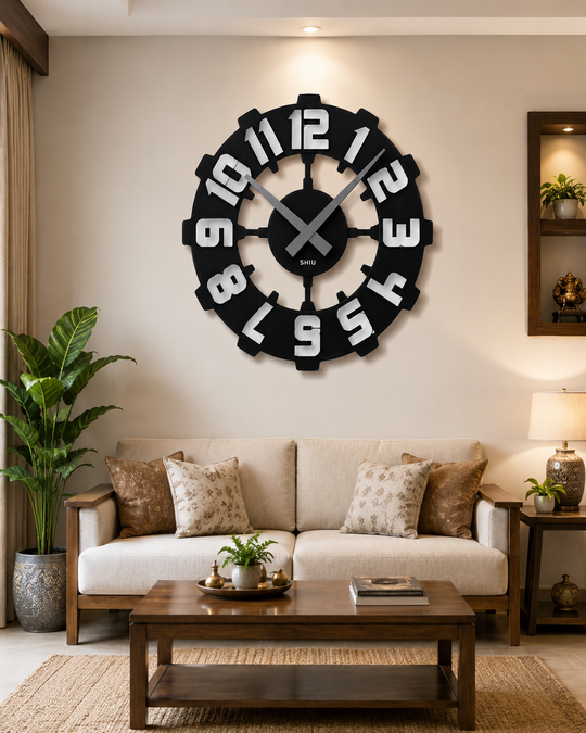 Statement SHIU industrial gear wall clock mounted as the central wall decor above a cream couch in a contemporary apartment living room.
