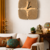 Large square SHIU wooden wall clock with a sunburst optical illusion pattern styled above a beige sofa in a modern Indian living room with traditional brass decor.