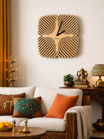 Large square SHIU wooden wall clock with a sunburst optical illusion pattern styled above a beige sofa in a modern Indian living room with traditional brass decor.