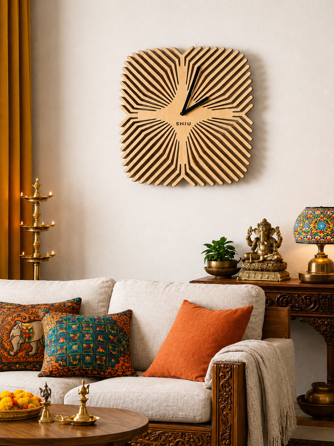 Large square SHIU wooden wall clock with a sunburst optical illusion pattern styled above a beige sofa in a modern Indian living room with traditional brass decor.