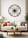 Large SHIU black polygon wall clock displayed as a contemporary centerpiece above a cream-colored sofa in a modern living room.