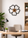 Minimalist SHIU flower outline wall clock displayed as office decor on a white wall above a wooden desk with a laptop.