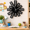 Playful SHIU abstract black word clock mounted on a white brick wall above a child's wooden study desk setup.