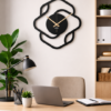 Contemporary SHIU black abstract continuous line clock hanging on a white wall above a modern wooden office desk with a laptop and a tan chair.